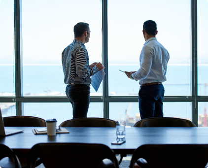 2 men are talking in a meeting room